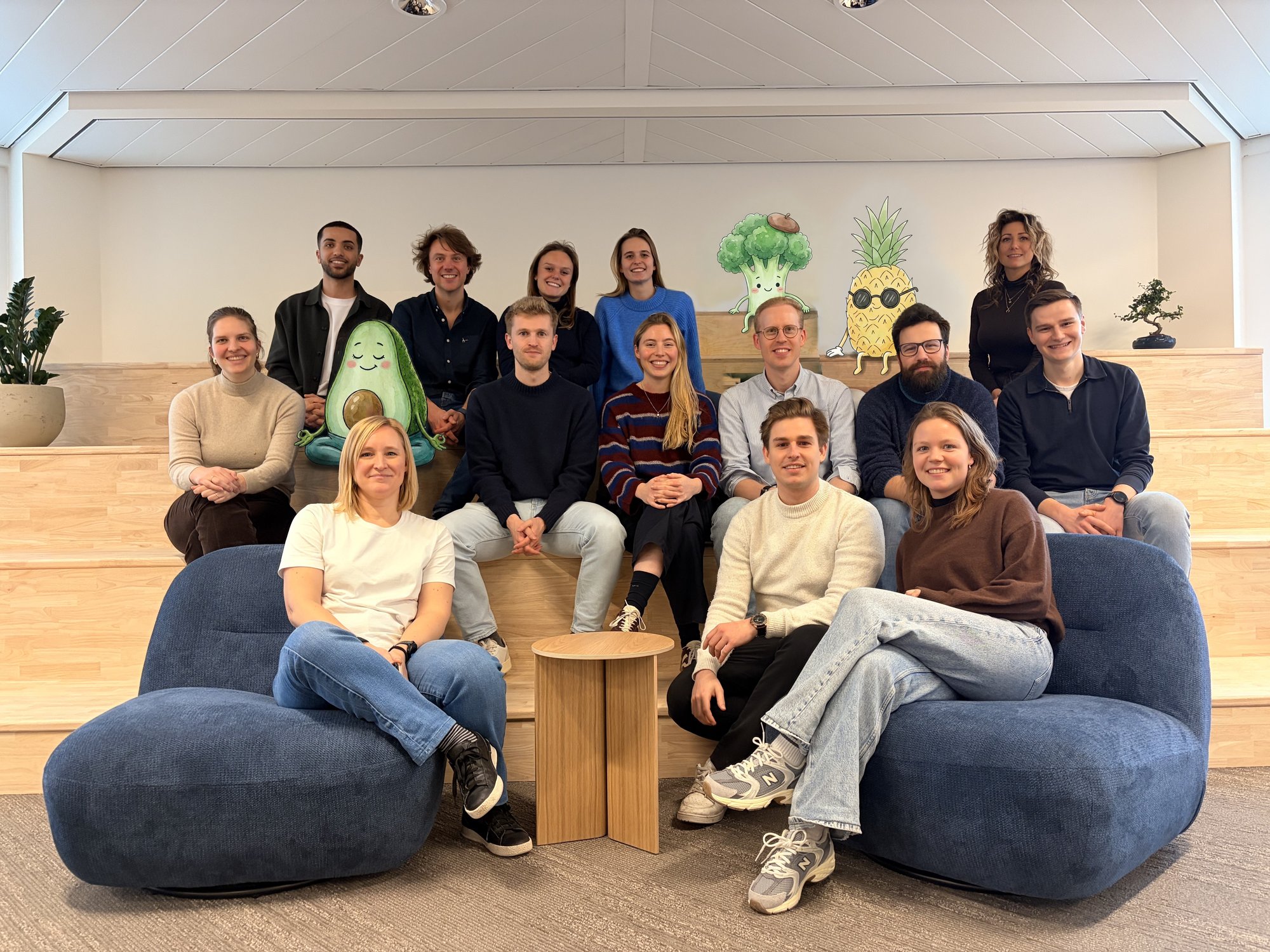 Het BiometrIQ-team, zittend op houten treden en twee blauwe zetels